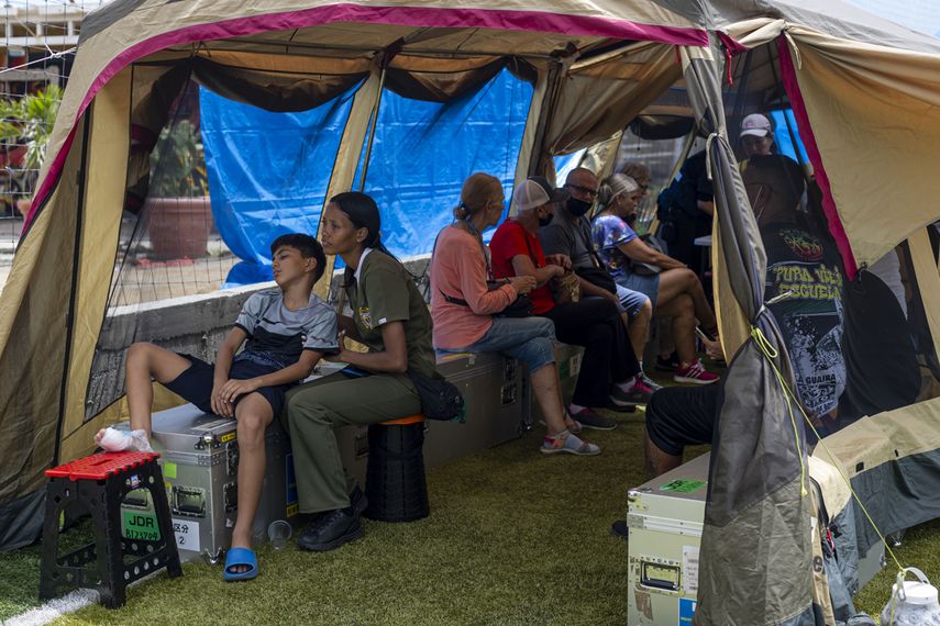Personas heridas entre damnificados esperan ser atendidos en el hospital de campaña de Japón en Caraballeda, en La Guaira, tras los sismos en Venezuela, este 14 de julio 2026