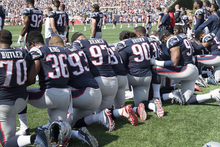 Los jugadores de New England Patriots toman las manos y se arrodillan durante el Himno Nacional antes del comienzo de su juego contra los Houston Texans en el estadio Gillette en Foxboro, Massachusetts, EEUU, este 24 de septiembre de 2017.