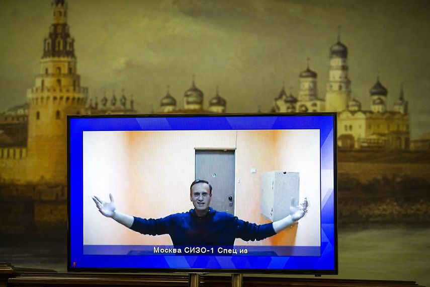 Alexei Navalny aparece en una pantalla de televisión durante una audiencia judicial en la que apela su encarcelamiento, con una imagen del Kremlin de fondo en Moscú&nbsp;