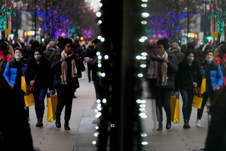 Compradores se reflejan en una ventana mientras caminan por Oxford Street, la calle para compras más ajetreada de Europa, en Londres, el jueves 23 de diciembre de 2021.