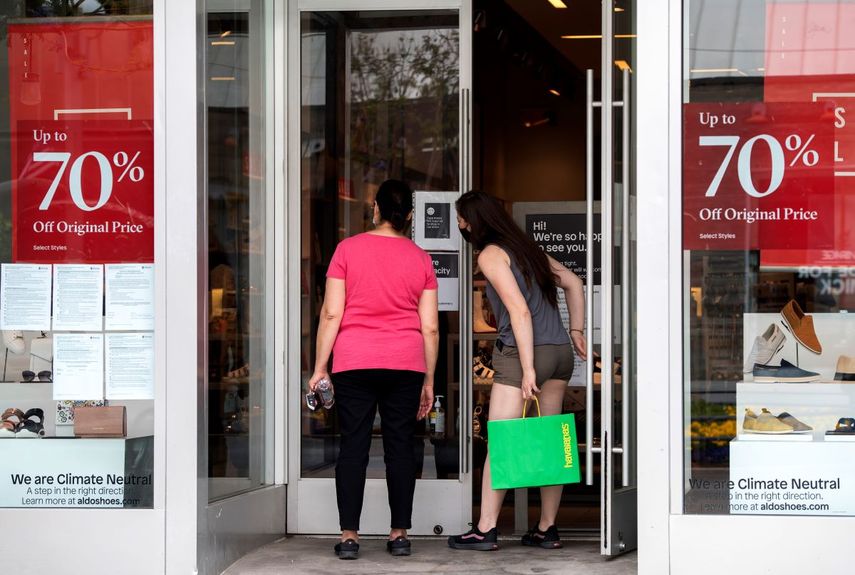 Dos mujeres observan productos antes de entrar a una tienda de Macys.