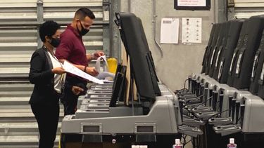 Votantes acuden a votar con mascarillas.