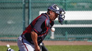 El receptor de los Bravos de Atlanta Gerald Laird bloquea la pelota mientras le rebota de frente durante los entrenamientos del martes 18 de febrero de 2014 en Kissimmee, Florida. Grandes Ligas dará a conocer el lunes sus nuevas reglas sobre los choque
