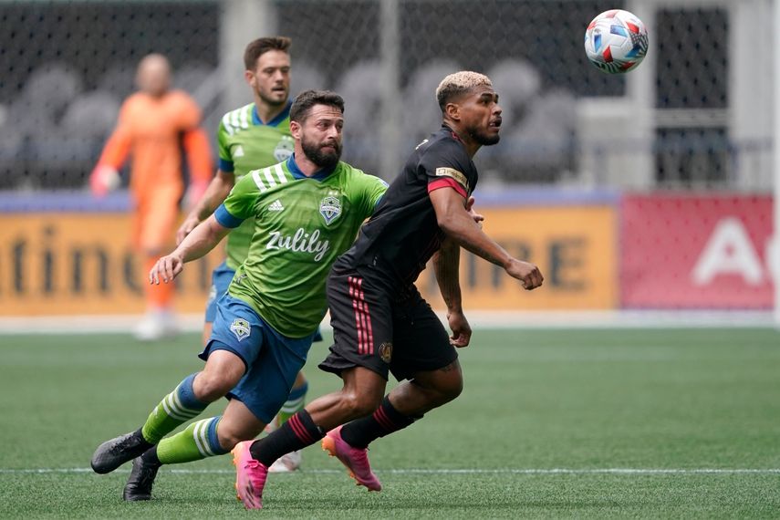El delantero venezolano Josef Martínez (derecha) del Atlanta United controla el balón ante el mediocampista Joao Paulo, del Sounders de Seattle, en un un partido de la MLS, el domingo 23 de mayo de 2021, en Seattle
