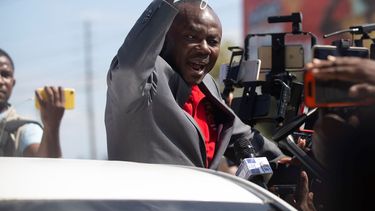 El exsenador haitiano Moise Jean-Charles habla con los medios de comunicación desde un vehículo en el Aeropuerto Internacional Toussaint Louverture, en Puerto Príncipe, Haití, el martes 25 de enero de 2022