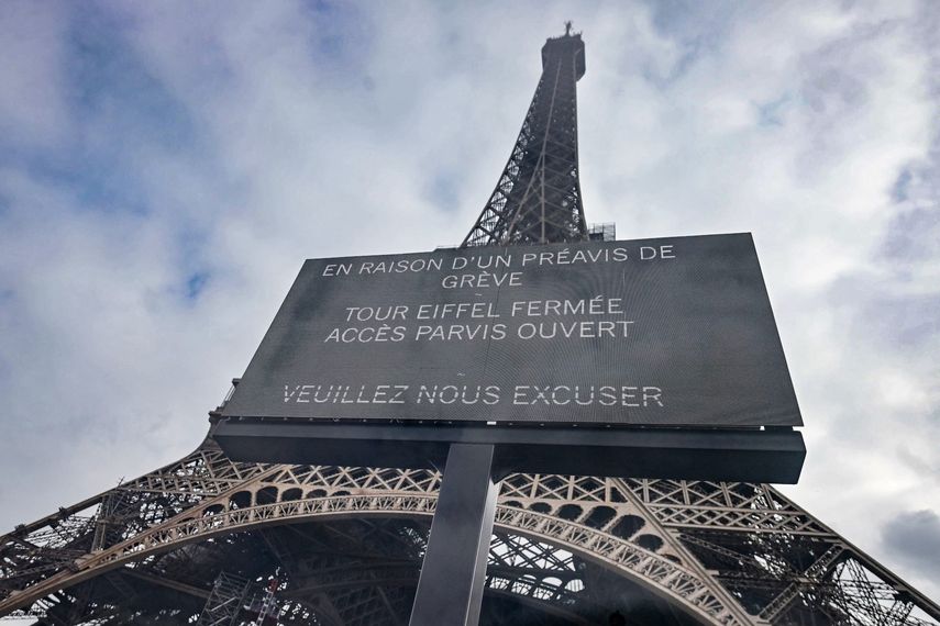 Una fotografía tomada a través de un panel de vidrio muestra un cartel digital que muestra un mensaje que dice Debido a una huelga, la Torre Eiffel está cerrada, la Explanada está abierta, nos disculpamos en la Torre Eiffel de París el 7 de marzo de 2023, durante un día de huelgas a nivel nacional y protestas convocadas por sindicatos por la reforma de las pensiones propuesta por el gobierno. La Torre Eiffel estará cerrada al público el 27 de diciembre de 2023 debido a una huelga. &nbsp;