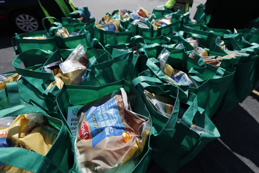 Bolsas con alimentos frescos para ser entregadas en un evento patrocinado por el grupo Greater Chicago Food Depository en el barrio Auburn Gresham de Chicago. (AP Foto/Charles Rex Arbogast)