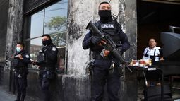 Policías fuertemente armados vigilan las calles del centro de San Salvador, El Salvador, el domingo 27 de marzo de 2022. El Congreso de El Salvador accedió al pedido del presidente Nayib Bukele de declarar el estado de emergencia, en medio de una ola de asesinatos relacionados con pandillas durante el fin de semana.