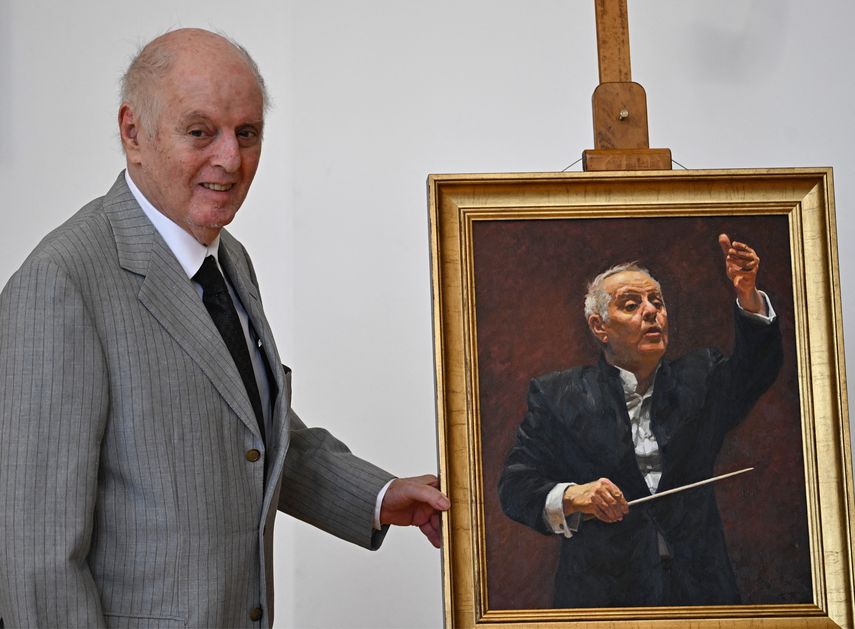 Daniel Barenboim, pianista y director de orquesta clásico nacido en Argentina, posa junto a su retrato realizado por el artista chino Du Wenjie durante la ceremonia de inauguración de su obra como ciudadano honorario de Berlín, el 11 de septiembre de 2023 en la Cámara de Representantes de Berlín.