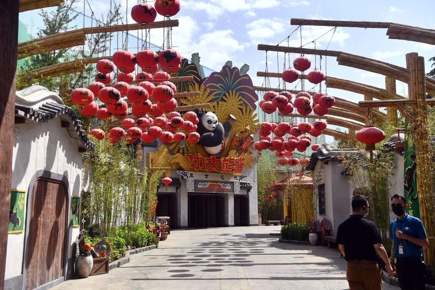 En esta foto del 26 de mayo de 2021, hombres con mascarillas en el parque temático Universal Studios, parte del Universal Beijing Resort en construcción en Beijing, China.