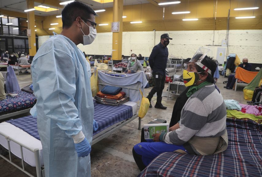 El doctor Jorge Cuzquen, izquierda, habla con el preso V&iacute;ctor Santos mientras usa una mascarilla protectora en una secci&oacute;n de prisioneros infectados con COVID-19 en la prisi&oacute;n de Lurigancho a las afueras de Lima, Per&uacute;, el mi&eacute;rcoles 19 de agosto de 2020.