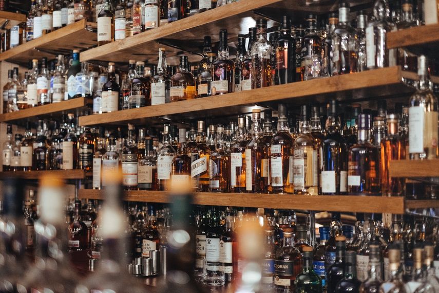 Imagen referencial de un frente de bar con numerosas botellas de bebidas alcohólicas. 