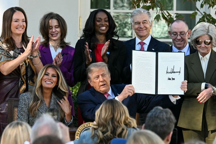 El presidente Donald J. Trump junto a su esposa Melania muestra la orden ejecutiva firmada para ampliar las investigaciones sobre la salud de la mujer.