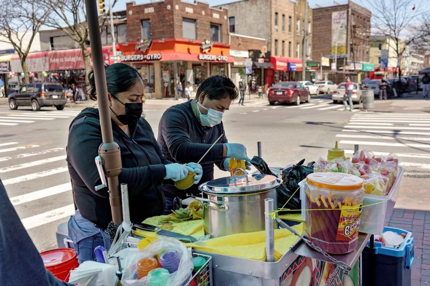 Ruth Palacios (izq) y su esposo Arturo Xelo trabajando en un puesto callejero de venta de frutas en el barrio de Corona, en Queens, Nueva York.