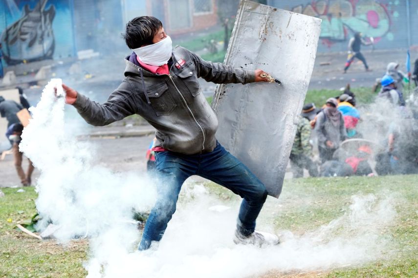 Un manifestante devuelve un bote de gas lacrimógeno durante los enfrentamientos con la policía en el centro de Quito, Ecuador, el viernes 24 de junio de 2022