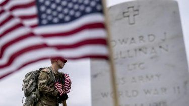 Soldado del Ejército de Estados Unidos ubica banderas en cada una cada una de las tumbas donde descansan los restos de soldados estadounidenses caídos en las distintas guerras.