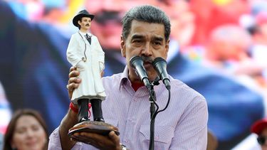 El dictador de Venezuela, Nicolás Maduro, sostiene una imagen del médico venezolano José Gregorio Hernández durante un mitin político.