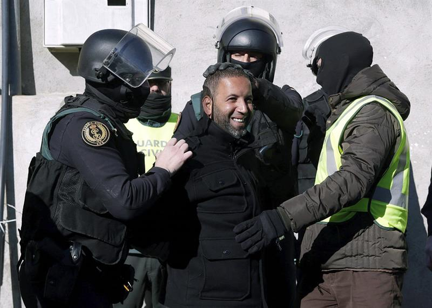 Agentes de la Guardia Civil trasladan a uno de los cuatro detenidos. (Foto: EFE)