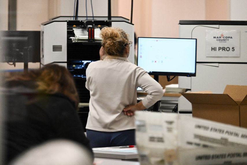 Una trabajadora monitoriza la máquina de tabulación que cuenta las boletas de votación, en Phoenix, Arizona.&nbsp;