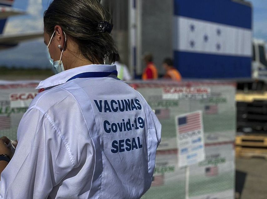 Imagen del folleto publicado por la Presidencia hondureña que muestra a los trabajadores de la Secretaría de Salud de Honduras descargando 1,5 millones de dosis de la vacuna Moderna donada por los Estados Unidos a través del esquema Covax, en la base aérea Armando Escalón, en San Pedro Sula, Honduras, el 27 de junio de 2021.