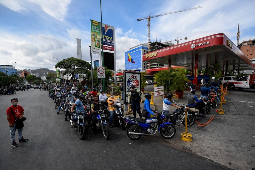 Los transe&uacute;ntes esperan en la cola para repostar los tanques de su motocicleta con gasolina en una estaci&oacute;n de servicio, en Caracas, el 7 de abril de 2020 en medio del nuevo brote de coronavirus (COVID-19). La econom&iacute;a de Venezuela atraviesa una crisis sin precedentes.