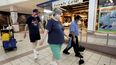Una pareja con mascarillas camina frente a un trabajador de limpieza en el centro comercial Gateway, en Lincoln, Nebraska, el viernes 1 de mayo de 2020.&nbsp;