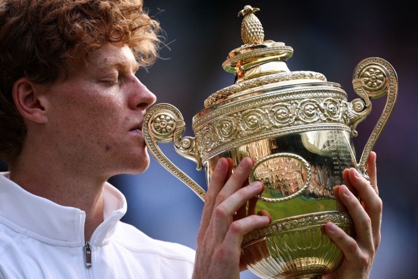 El italiano Jannik Sinner besa el trofeo de ganador mientras posa para fotos después de su victoria contra el español Carlos Alcaraz en&nbsp; Wimbledon 2025&nbsp;