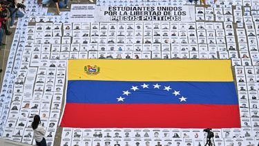 Personas muestran retratos de presos políticos durante una manifestación de familiares en la Universidad Central de Venezuela en Caracas el 13 de enero de 2026.