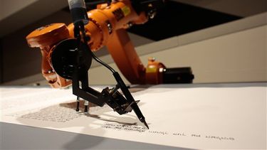 Un robot escribe la Torá, las sagradas escrituras hebreas, en el Museo Judío de Berlín, el jueves 10 de julio de 2014. (Foto AP/Markus Schreiber)