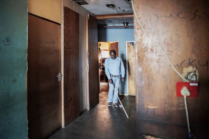 Jetro Gonese, de 60 a&ntilde;os, una persona ciega de Zimbabwe, camina por el pasillo del edificio en el que vive mientras usa su bast&oacute;n blanco, en el CBD de Johannesburgo, el 22 de junio de 2020.&nbsp;
