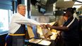 Un empleado entrega una orden al candidato presidencial republicano, el expresidente Donald Trump, durante una visita a un McDonalds, el domingo 20 de octubre de 2024, en Feasterville-Trevose, Pennsylvania.