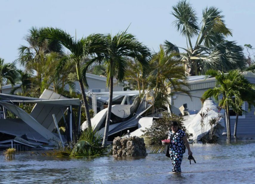 Holly Nugyn camina en su vecindario inundado y con casas destruidad por el paso del huracán Ian, en Fort Myers, en septiembre de 2022.