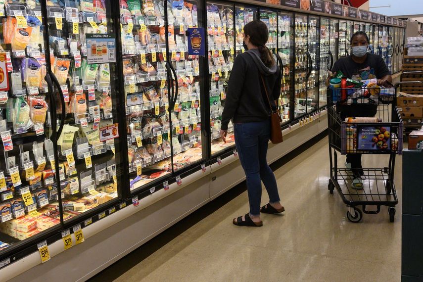 Una mujer observa los altos precios de los alimentos en un supermercado