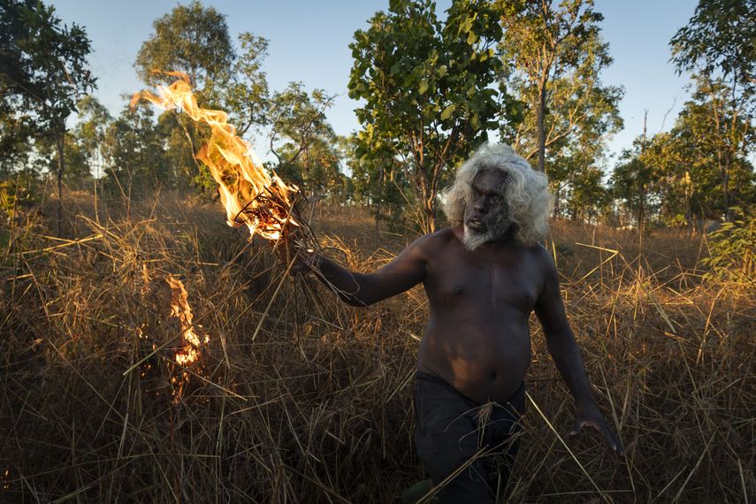 Esta imagen, distribuida por World Press Photo y que fue elegida ganadora en la categoría de Historia del Año, tomada por Matthew Abbott para National Geographic Magazine/Panos Pictures, titulada Salvar el bosque con fuego, muestra a un anciano nawarddeken, Conrad Maralngurra, quemando la hierba para proteger a la comunidad de Mamadawerre de los incendios forestales, en Mamadawerre, Arnhem Land, Australia, el 3 de mayo de 2021.