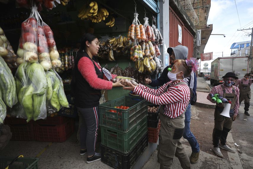 Alexandra Calabacita Su&aacute;rez, miembro de la compa&ntilde;&iacute;a del grupo Circo Encuentro, recibe vegetales donados con los que preparar&aacute;n una gran sopa para personas de bajos recursos afectados por la pandemia del nuevo coronavirus, en Bogot&aacute;, Colombia, el s&aacute;bado 4 de julio de 2020.&nbsp;