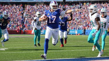 Josh Allen (17), quarterback de los Bills de Búfalo, corre rumbo a la zona de anotación para un touchdown en frente del safety de los Dolphins de Miami, Jevon Holland, durante la segunda mitad del juego de la NFL, el domingo 1 de octubre de 2023, en Orchard Park, Nueva York.