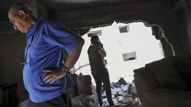 Vecinos de la localidad de Petah Tikva, en Israel, miran con asombro los daños ocasionados por un misil de Hamas en su apartamento.
