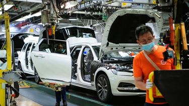 Empleados trabajan en una planta de ensamblaje de autos.