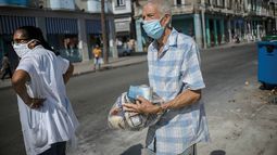 Un cubano lleva entre sus manos una ración mensual de alimentos.