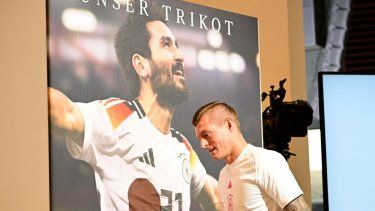 El centrocampista alemán #8 Toni Kroos camina junto a un cartel de su compañero Ilkay Gundogan cuando llega a una conferencia de prensa en el campo de entrenamiento del equipo en Herzogenaurach el 11 de junio de 2024, antes de la competición de fútbol UEFA EURO 2024. &nbsp;