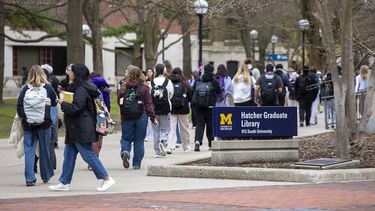 Estudiantes de la Universidad de Michigan, en Ann Arbor, caminan por el campus de la UM en abril de 2025.