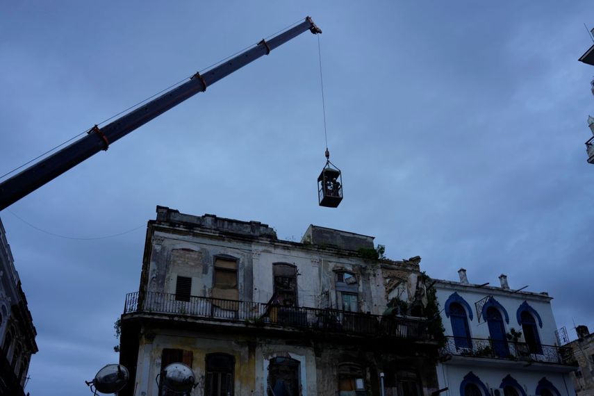 Una grúa levanta a los bomberos en una jaula hacia un edificio en busca de sobrevivientes después de que colapsara parcialmente en La Habana, Cuba, el miércoles 4 de octubre de 2023.