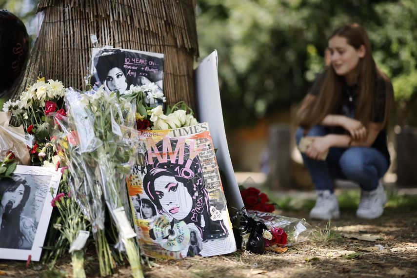 Los fanáticos se reúnen en un santuario temporal cerca de la antigua casa de la cantante británica Amy Winehouse en el norte de Londres, el 23 de julio de 2021 para conmemorar el décimo aniversario de su muerte.
