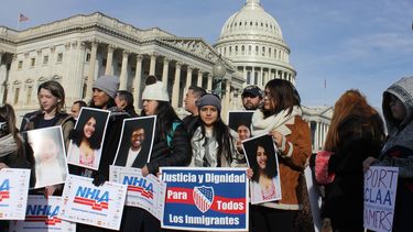 Varios jóvenes sostienen pancartas que reivindican Justicia y dignidad para todos los inmigrantes frente al Capitolio nacional en Washington.
