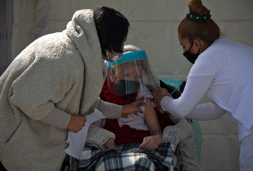 Una mujer recibe su primera dosis de la vacuna AstraZeneca contra COVID-19 en la Ciudad de México, el 15 de febrero de 2021, cuando México comienza a vacunar a personas mayores de 60 años. México inició este lunes la segunda fase de su plan de vacunación masiva contra COVID-19 con personas mayores de 60 años. La primera fase, que se centró en el personal médico, duró casi un mes debido a retrasos en la entrega de las dosis.