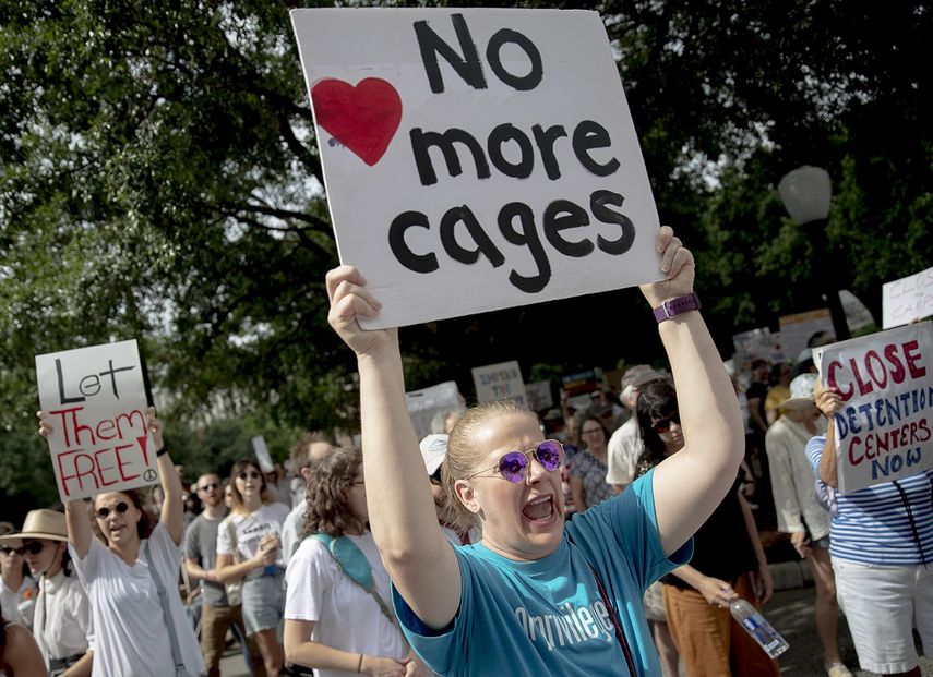 Una mujer grita consignas mientras sostiene una pancarta durante una protesta contra la detención de niños migrantes en la frontera de EEUU el jueves 4 de julio de 2019, en Austin, Texas.
