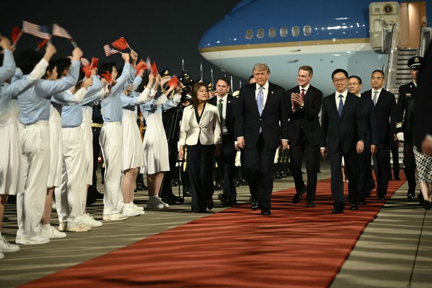 El presidente de Estados Unidos, Donald Trump (C), y el embajador de Estados Unidos en China, David Perdue (centro-derecha), acompañados por el vicepresidente de China, Han Zheng (derecha), son recibidos por jóvenes chinos a su llegada al Aeropuerto Internacional de Pekín el 13 de mayo de 2026.&nbsp;