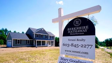 Un cartel de inmobiliaria frente a una casa unifamiliar nueva en venta en Auburn, Nuevo Hampshire.