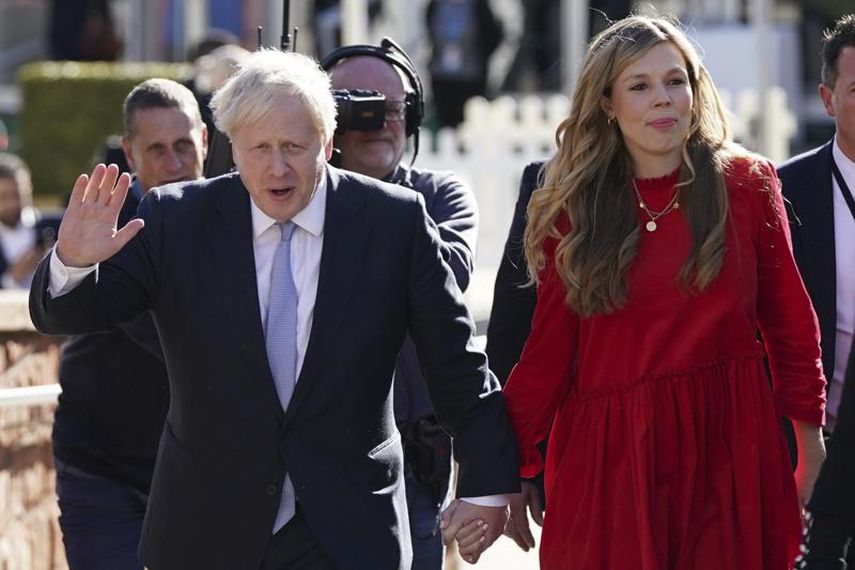 En esta imagen de archivo, el primer ministro de Gran Bretaña, Boris Johnson, saluda a la prensa a su salida de un centro de convenciones con su esposa, Carrie Johnson, antes de participar en la conferencia del partido Conservador en Manchester, Inglaterra, el 6 de octubre de 2021.&nbsp;
