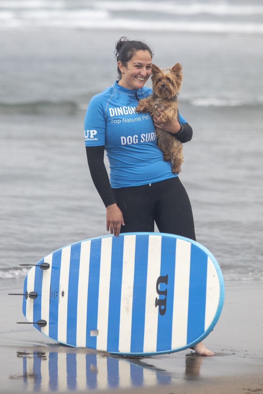 Una surfista participa con su perro en el II Campeonato Europeo de Surf para Perros Dingonatura Surf Dog, en la playa de Salinas, a 21 de mayo de 2023, en Castrillón, Asturias (España).&nbsp;